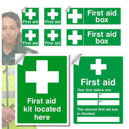 Collection of green first aid signs with white crosses and text, including 'First aid box' and 'First aid kit located here'.